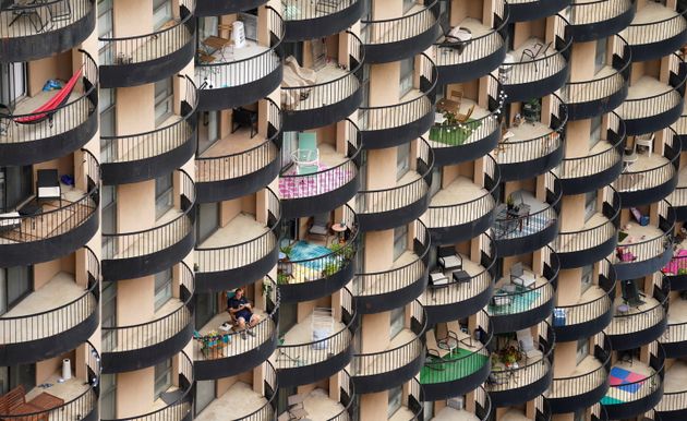 A man sits on his balcony at an apartment building in Arlington, Virginia, on Oct. 13.