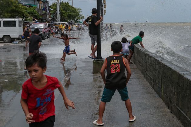 Children play in floodwater near the polluted Manila Bay in the Philippines in July