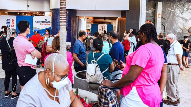 People wearing face masks line up at a Covid-19 testing site at Orlando International Airport.