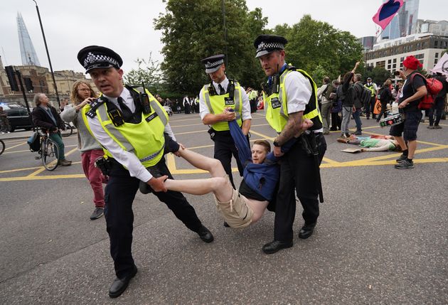 <strong>Police remove a man as members of Extinction Rebellion reach Tower Hill during their march in central London.</strong>