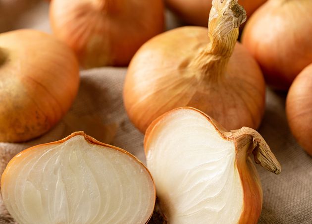 Raw onion on textured linen sackcloth. Organic onions