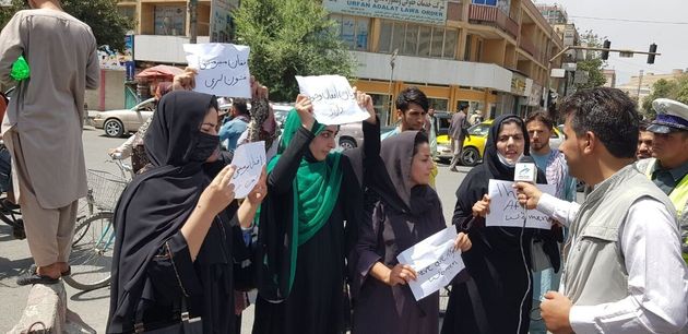 Afghan women, holding placards, gather to demand the protection of Afghan women's rights in front of the Presidential Palace in Kabul