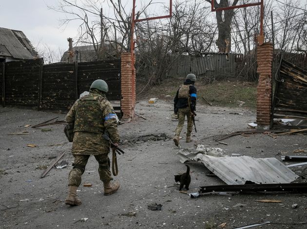 Ukrainian service members walk on the front line near Kyiv as Russia's invasion of Ukraine continues on Tuesday.