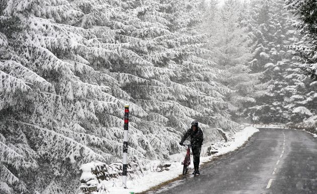 A person trying to cycle in the Pennines on Wednesday March 30, 2022.