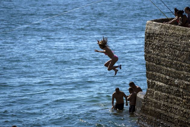 People jump into the sea at Brighton beach in West Sussex. 