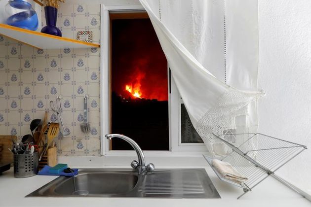 Lava is seen through the window of a kitchen from El Paso following a volcanic eruption on the Canary Island of La Palma, Spain, on Tuesday