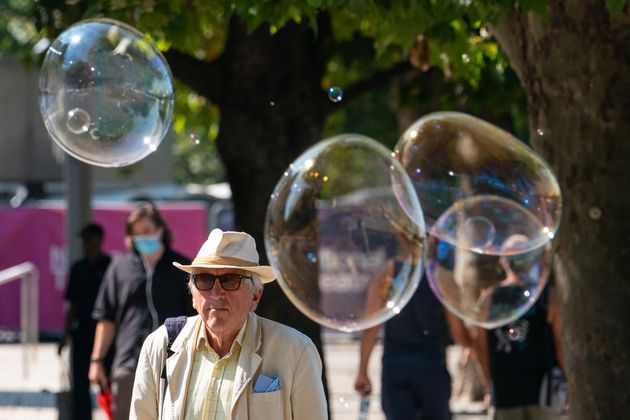 A man walks among giant bubbles from a street performer on the South Bank, London. 