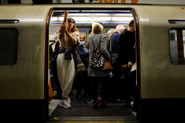 <strong>Commuters, some wearing face coverings to help prevent the spread of coronavirus, wait for the Tube.</strong>