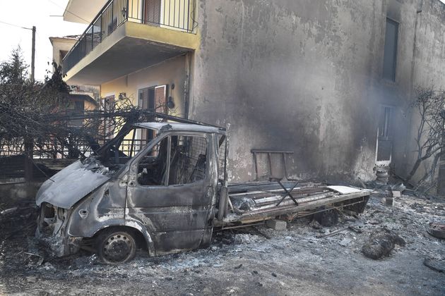 The remains of a van sits amongst burned trees and rubble as Greece swelters in a record-breaking heatwave.