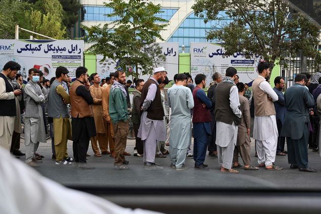 <strong>Afghans queue up as they wait for the banks to open and operate at a commercial area in Kabul.</strong>