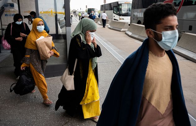 Refugees from Afghanistan board a bus after arriving and being processed at Dulles International Airport in Dulles, Virginia on August 23, 2021