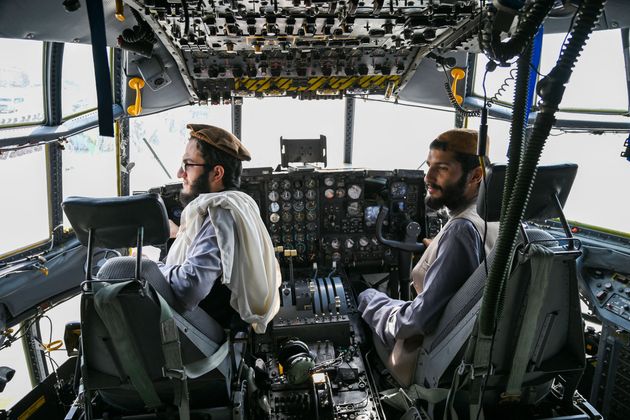 <strong>Taliban fighters sit in the cockpit of an Afghan Air Force aircraft at the airport in Kabul.</strong>