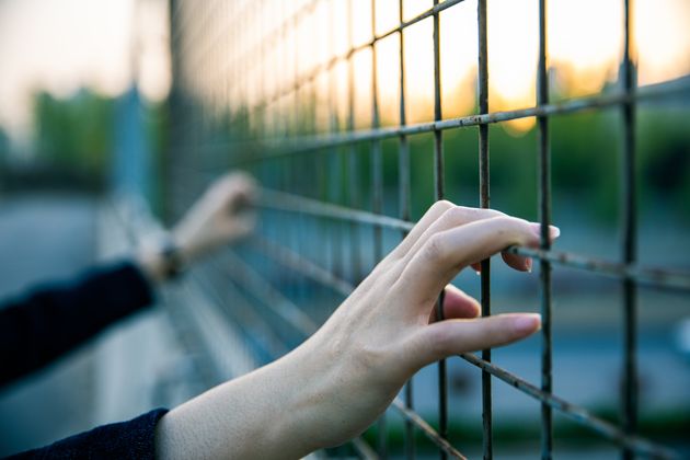 Woman's hand holding the fence