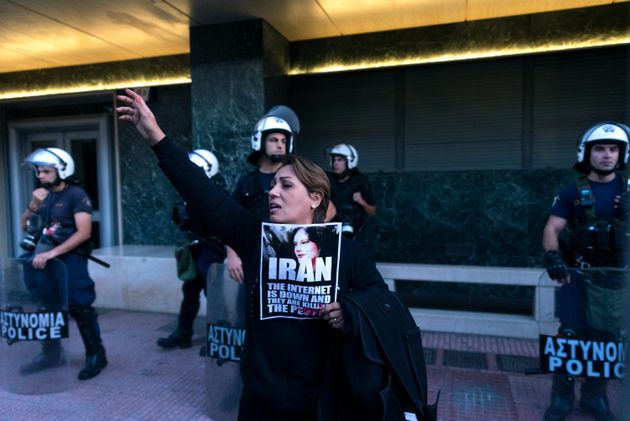 A protester shouts slogans outside the European Commission representative office in Athens during a protest Saturday against the death of Iranian Mahsa Amini.