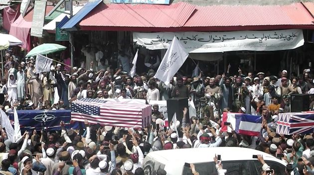 <strong>Crowd carries makeshift coffins draped in NATO's, US and a Union Jack flags during a mock funeral on a street in Khost, Afghanistan.</strong>