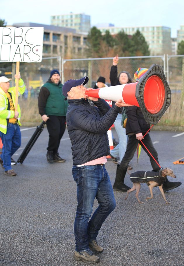 <strong>A protester uses a traffic cone as a megaphone as demonstrators disrupt the vaccination centre.</strong>