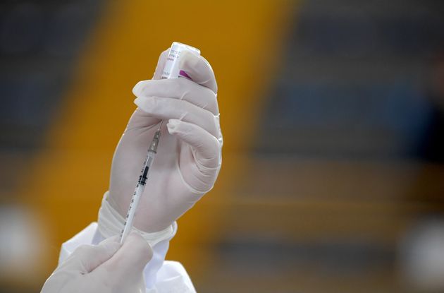 A health worker prepares a shot of the Oxford/AstraZeneca vaccine against Covid-19