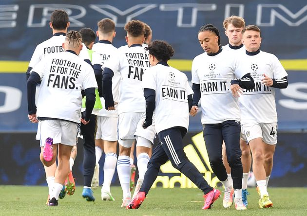Players of Leeds United warm up while wearing protest t-shirts reading 