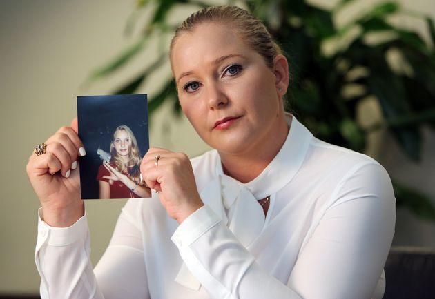 Virginia Giuffre holds a photo of herself at age 16