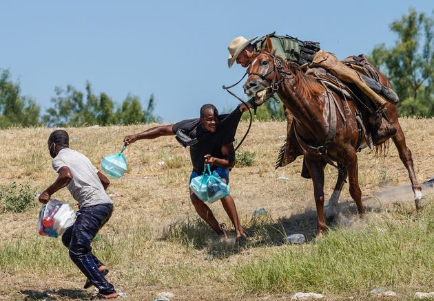 A border patrol agent on horseback tries to stop a Haitian migrant from entering a camp in Del Rio, Texas 