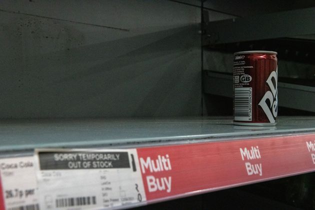 One remaining can of soft drink on a near-empty shelf at Asda