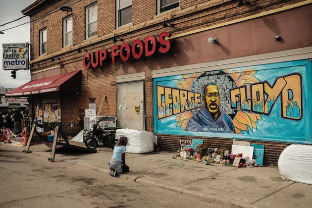 <strong>A woman pays respect to a mural of George Floyd by the Cup Foods where he was killed by Minneapolis Police Officer Derek Chauvin in Minneapolis, Minnesota.</strong>