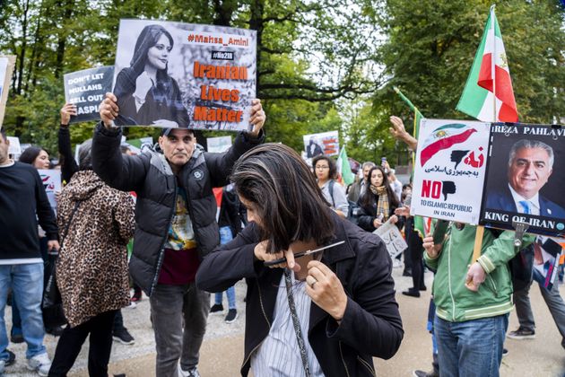 A protester cuts her hair during a rally against Iranian regime outside the House of Representatives in The Hague on Sept. 23, following the death of an Iranian woman after her arrest by the country's morality police in Tehran. 