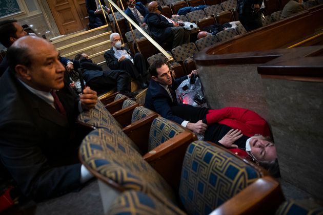 In this photo that went viral on January 6, Wild is lying on the ground as Rep. Jason Crow comforts her.