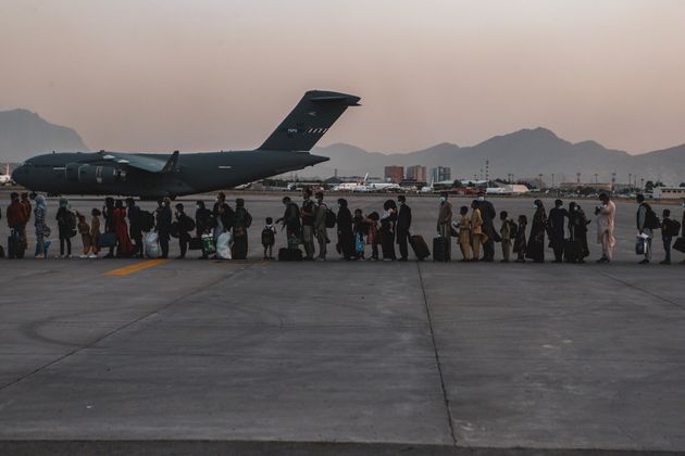 <strong>Evacuees wait to board a Boeing C-17 Globemaster III during an evacuation at Hamid Karzai International Airport in Kabul, Afghanistan.</strong>