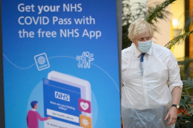 <strong>Boris Johnson walks past a poster advertising the NHS Covid Pass during a visit to a vaccination centre in Ramsgate, Kent.</strong>