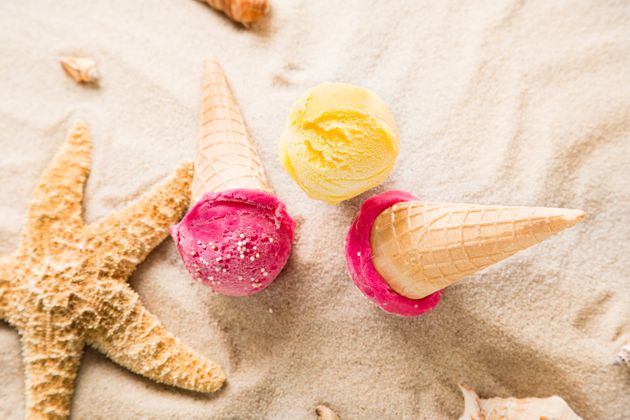 Ice cream scoops on sandy beach, close-up.