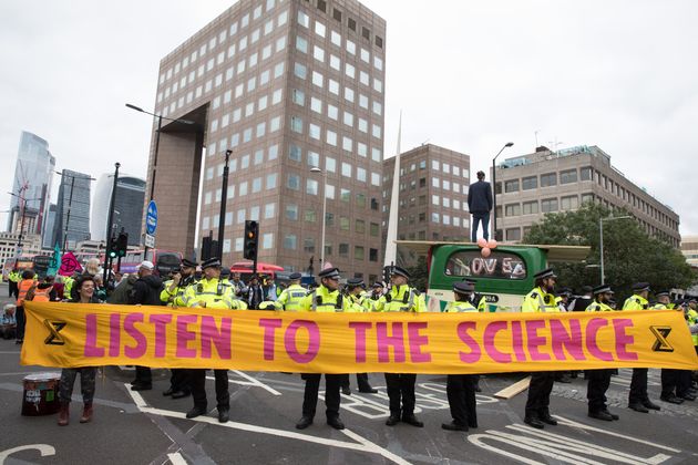 Environmental activists from Extinction Rebellion hold a banner calling on the government to cease all new fossil fuel investment