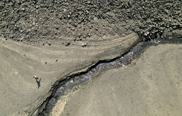 A person walks a dry bank of a tributary to the Dowry Reservoir close to Oldham, England, on Monday.