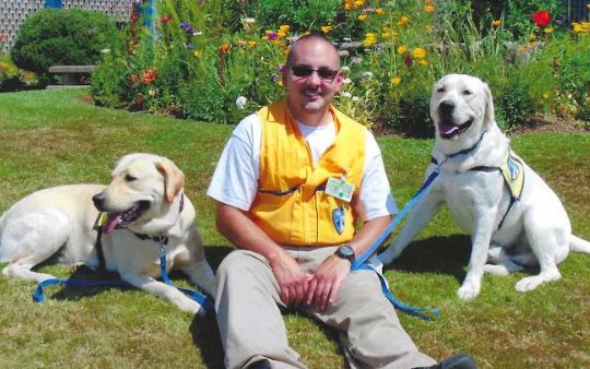 Leland Russell Jr. with two dogs in the training program at WCC.