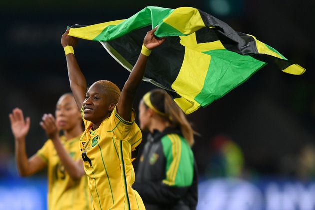 Player Deneisha Blackwood holds a Jamaican flag after the Reggae Girlz played the Brazilian team to a draw in Wednesday's FIFA Women's World Cup match.